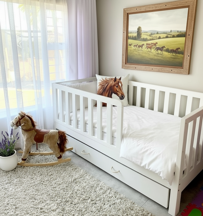 Children's room with a white toddler bed, rocking horse, and framed picture of horses.