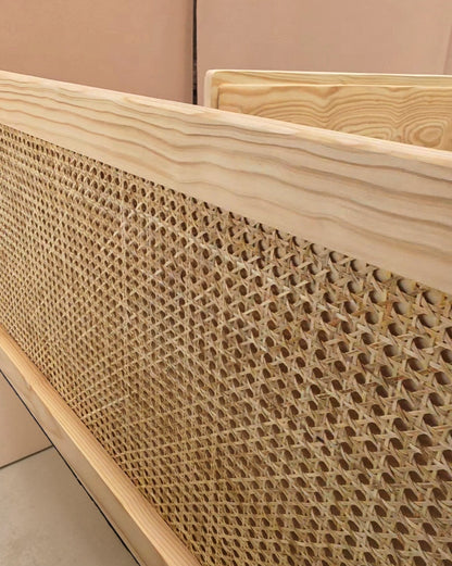 Close-up of a light natural wood frame with a woven cane or rattan panel, showing the texture and pattern of the woven material.