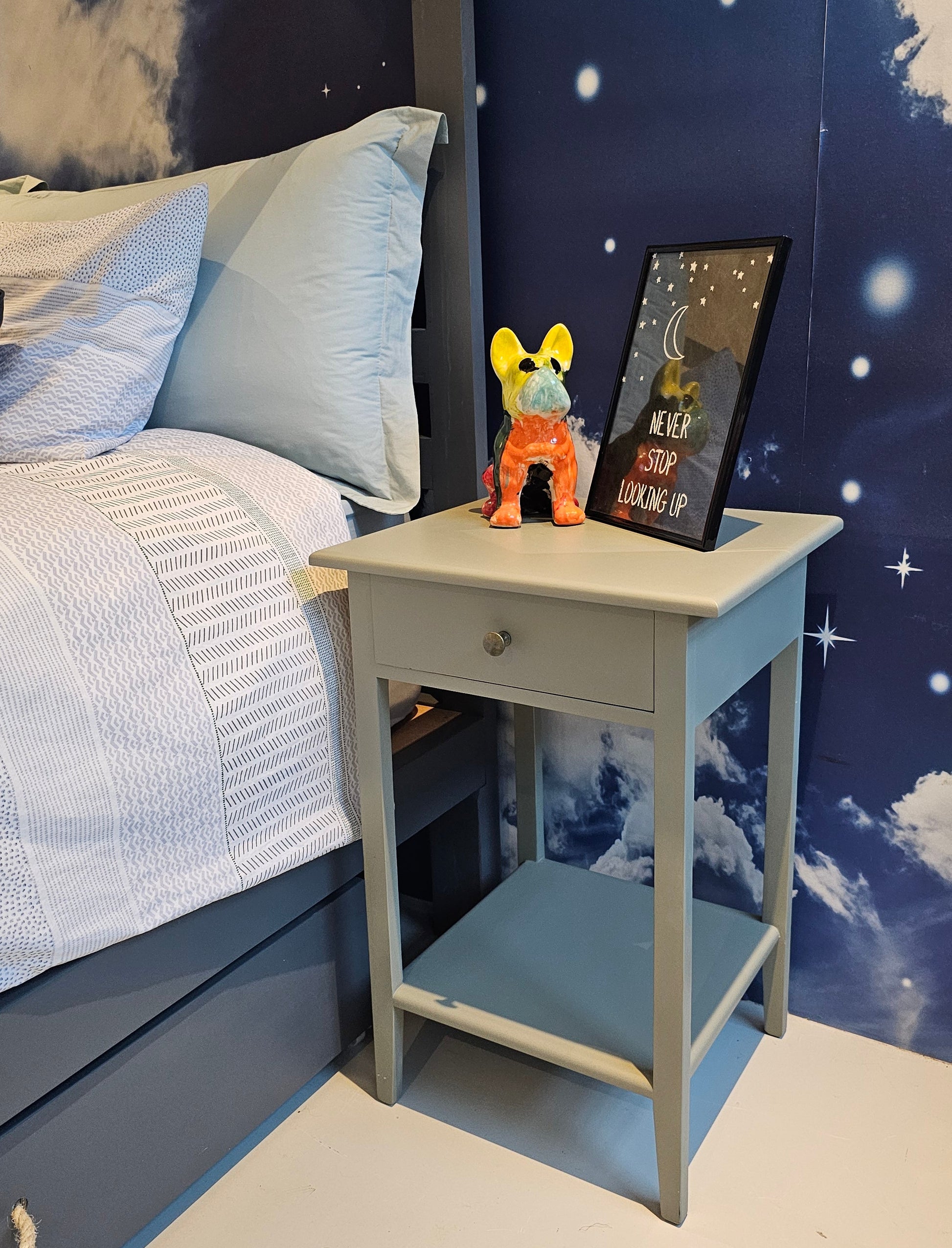 Children's room with space-themed decor, including a bed with starry night design and toys.