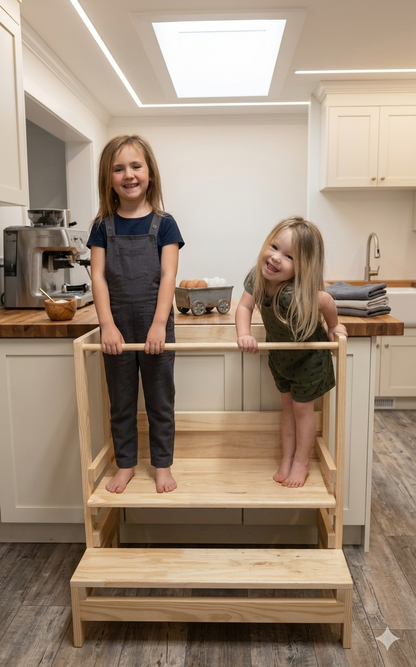 Two children standing on a wooden step stool in a kitchen.
